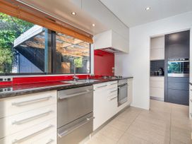 A kitchen with cabinets and a stove at Living The Dream - Matarangi Holiday Home in Matarangi
