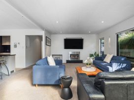 A living room with a television and sofa at Living The Dream - Matarangi Holiday Home in Matarangi