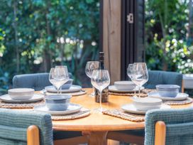 A table set with dinnerware and wine at Living The Dream - Matarangi Holiday Home Matarangi