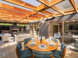 An outdoor dining area with a table and chairs at Living The Dream - Matarangi Holiday Home in Matarangi