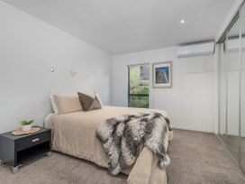 A bedroom with a bed and nightstand at Living The Dream - Matarangi Holiday Home Matarangi