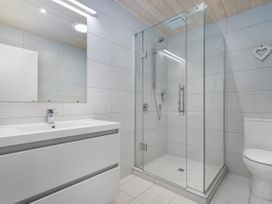 A bathroom with a shower, toilet, and sink at Living The Dream - Matarangi Holiday Home, Matarangi