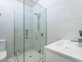 A bathroom with a shower and toilet at Living The Dream - Matarangi Holiday Home Matarangi