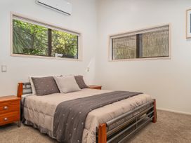 A bedroom with a bed and bedside tables at Living The Dream - Matarangi Holiday Home Matarangi