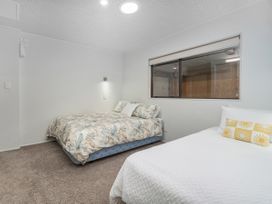 A bedroom with two beds and a window at Living The Dream - Matarangi Holiday Home Matarangi