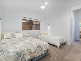 A bedroom with two beds and a window at Living The Dream - Matarangi Holiday Home in Matarangi