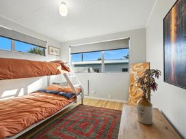 A bedroom with a bunk bed and a table at Birdlings Flat in Banks Peninsula