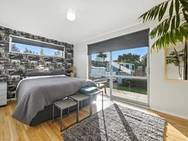 A bedroom with a bed and large windows at Birdlings Flat in Banks Peninsula