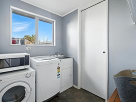 A laundry room with a washing machine and microwave at Birdlings Flat, Banks Peninsula