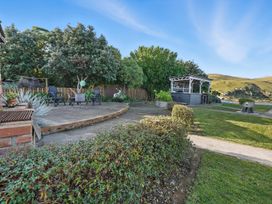 An outdoor patio with chairs and a garden structure at Birdlings Flat, Banks Peninsula