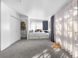 A bedroom with a bed, curtains and a wardrobe at Ohakune Holiday Home in Ohakune
