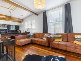 A living room with a sofa and kitchen area at Ohakune Holiday Home in Ohakune