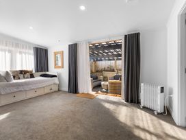 A living room with a daybed and outdoor seating at Ohakune Holiday Home in Ohakune
