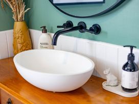 A bathroom sink with a bowl, faucet, and moisturizing lotion at Ohakune Holiday Home in Ohakune