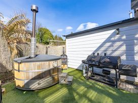 An outdoor area with a hot tub and barbecue grill at Ohakune Holiday Home in Ohakune