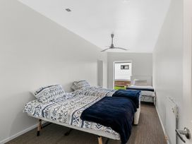 A bedroom with two beds and a window at Mangawhai Heads Holiday Home Mangawhai Heads