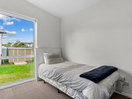 A bedroom with a bed and window at Mangawhai Heads Holiday Home in Mangawhai Heads