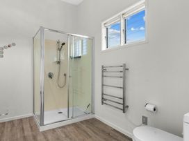 A bathroom with a shower and toilet at Mangawhai Heads Holiday Home in Mangawhai Heads