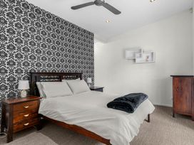 A bedroom with a bed and nightstands at Mangawhai Heads Holiday Home Mangawhai Heads