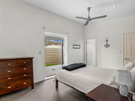 A bedroom with a bed and dresser at Mangawhai Heads Holiday Home, Mangawhai Heads