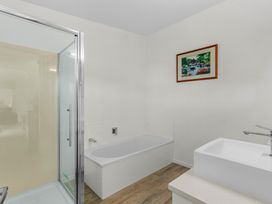 A bathroom with a shower, bathtub, and sink at Mangawhai Heads Holiday Home Mangawhai Heads