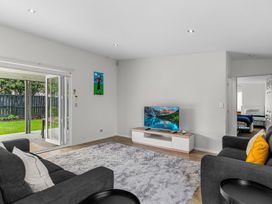 A living room with a sofa and television at Mangawhai Heads Holiday Home in Mangawhai Heads