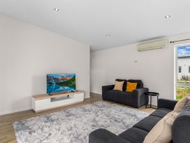 A living room with a sofa and a television at Mangawhai Heads Holiday Home in Mangawhai Heads