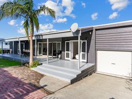 An outdoor area with seating and palm tree at Mangawhai Heads Holiday Home Mangawhai Heads