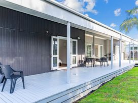 An outdoor area with chairs and a table at Mangawhai Heads Holiday Home Mangawhai Heads