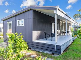 A house with a deck and furniture at Mangawhai Heads Holiday Home Mangawhai Heads