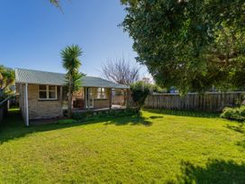 A house with a yard and trees at They Carolyn - Whangamata Holiday Home, Whangamata