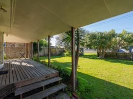 An outdoor area with a deck and table at They Carolyn - Whangamata Holiday Home, Whangamata