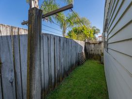 An outdoor area with a fence and clothesline at They Carolyn - Whangamata Holiday Home, Whangamata
