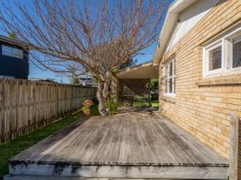 A deck with a tree and fence at They Carolyn - Whangamata Holiday Home in Whangamata