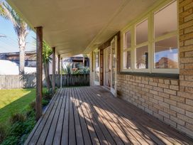 A deck area with wooden flooring at They Carolyn - Whangamata Holiday Home Whangamata