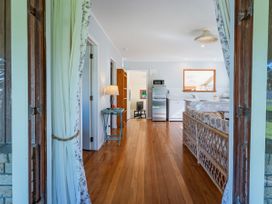 A kitchen with a view from the doorway at They Carolyn - Whangamata Holiday Home in Whangamata