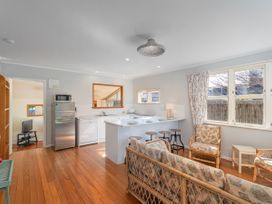 A kitchen with appliances and seating at They Carolyn - Whangamata Holiday Home, Whangamata