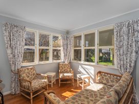 A sunroom with chairs and a sofa at They Carolyn - Whangamata Holiday Home in Whangamata