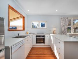 A kitchen with a sink and oven at They Carolyn - Whangamata Holiday Home, Whangamata