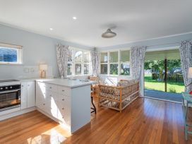 A kitchen with a sofa and outdoor view at They Carolyn - Whangamata Holiday Home, Whangamata