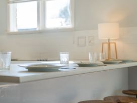 A kitchen with a countertop set up for dining at They Carolyn - Whangamata Holiday Home in Whangamata