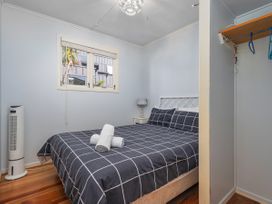 A bedroom with a bed and bedside table at They Carolyn - Whangamata Holiday Home in Whangamata