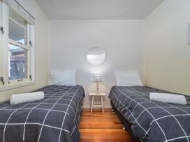 A bedroom with two beds and a lamp at They Carolyn - Whangamata Holiday Home in Whangamata