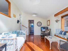 A living room with a sofa and television at The Carolyn - Whangamata Holiday Home Whangamata