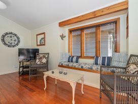 A living room with a television and seating at They Carolyn - Whangamata Holiday Home, Whangamata