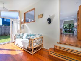 A living room with a sofa and curtains at They Carolyn - Whangamata Holiday Home in Whangamata