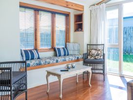 A snug with a window seat and table at They Carolyn - Whangamata Holiday Home in Whangamata