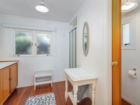 A bathroom with a sink, toilet, and shower at The Carolyn - Whangamata Holiday Home in Whangamata