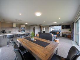 A living room with a dining table and sofa at Te Anau 