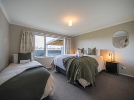 A bedroom with two beds and a window at Te Anau